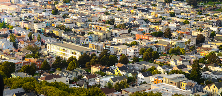 The golden glow of the setting sun hits the facade of thousands of homes in San Francisco, California
