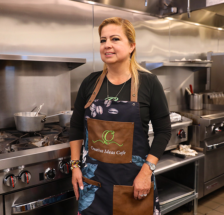 Woman business owner by a kitchen.
