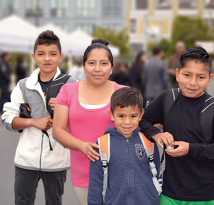 Mother with three children outside a school.