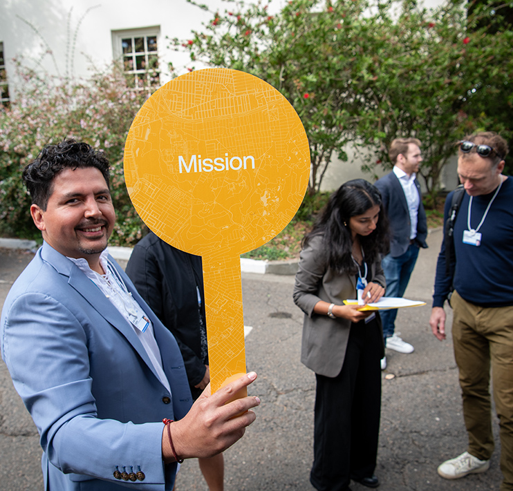 Man with a sign that reads Mission.